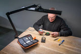 SBR Professional Black Daylight Lamp — 45W LED desk lamp for jewelers and precision work. Man doing detailed word with sbr lamp.
